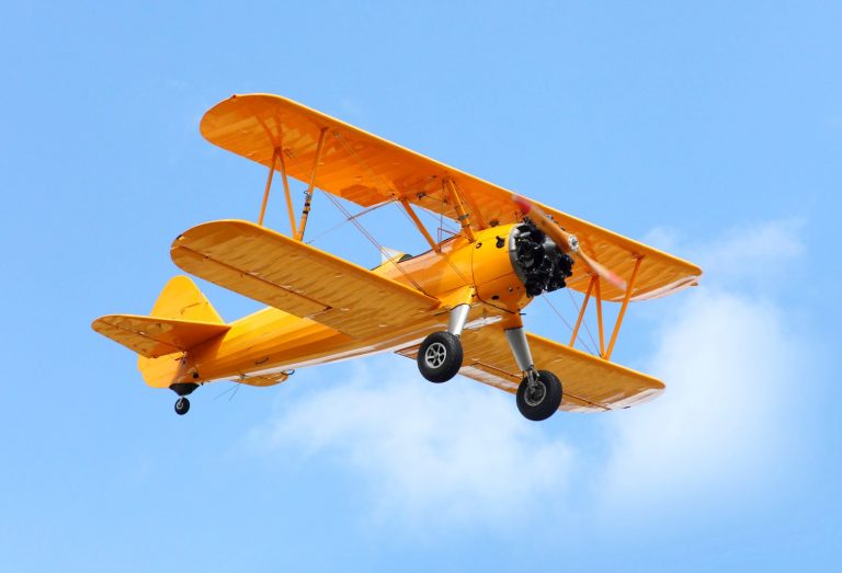 Bright yellow biplane against a blue sky