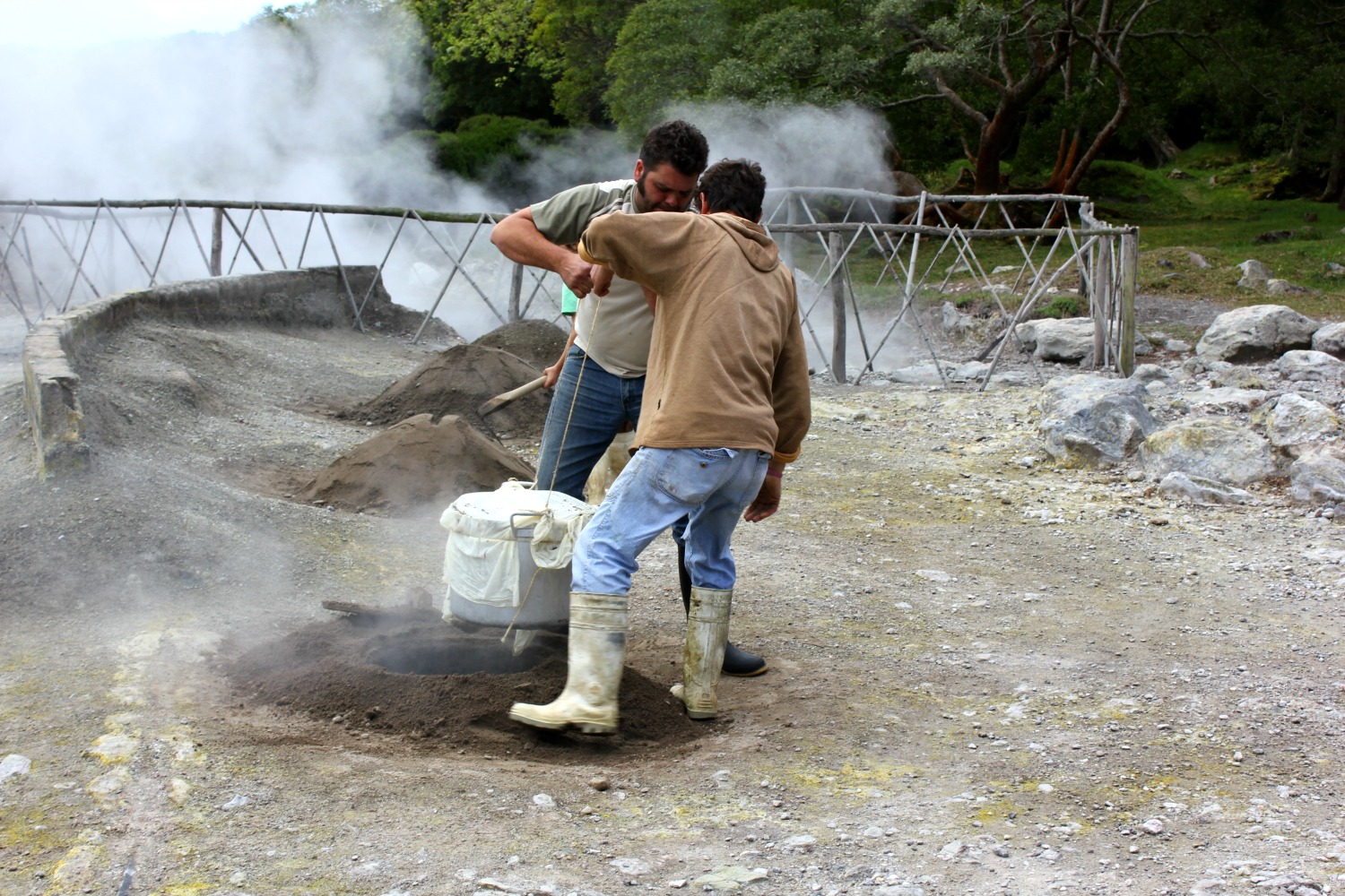 furnas-azores-cozido-volcano Two men lift the cozido out of the ground, food cooked in the volcanic heat of the Azores