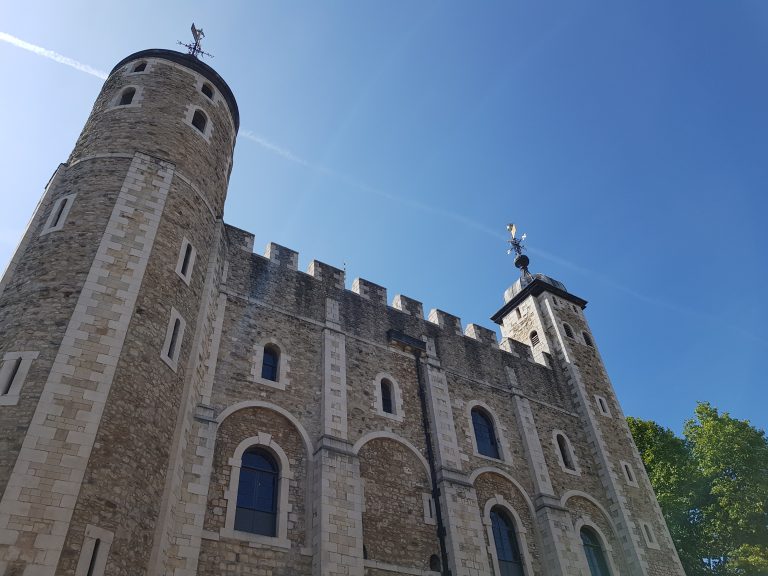 A view of the Tower of London against a blue sky