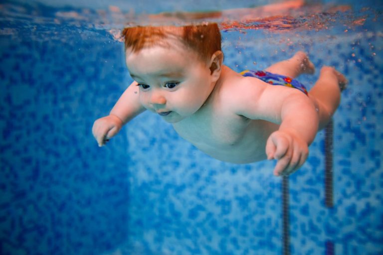 Baby smiling underwater in a swimming pool - my review of the Splash About Happy Nappy (not pictured)