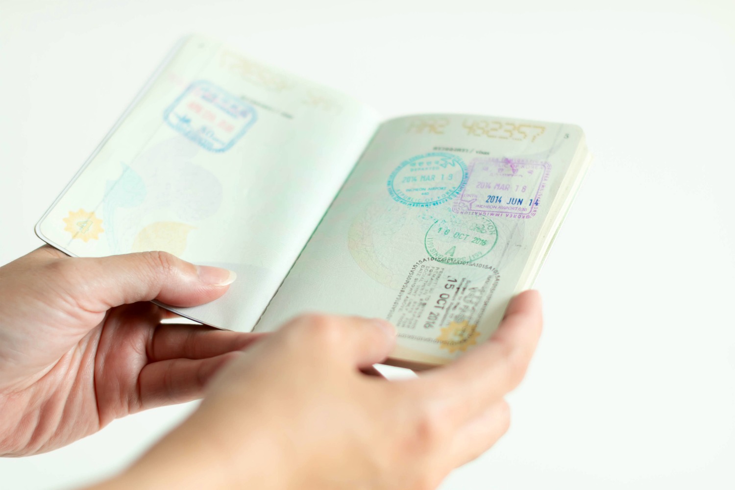 Woman's hands holding open passport - sorting the paperwork, including passport and baby travel insurance, for our first holiday