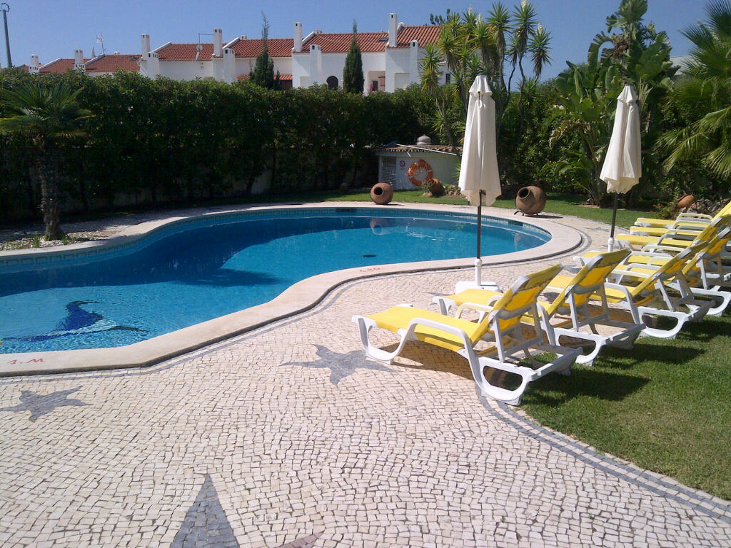Swimming pool with yellow loungers and umbrellas