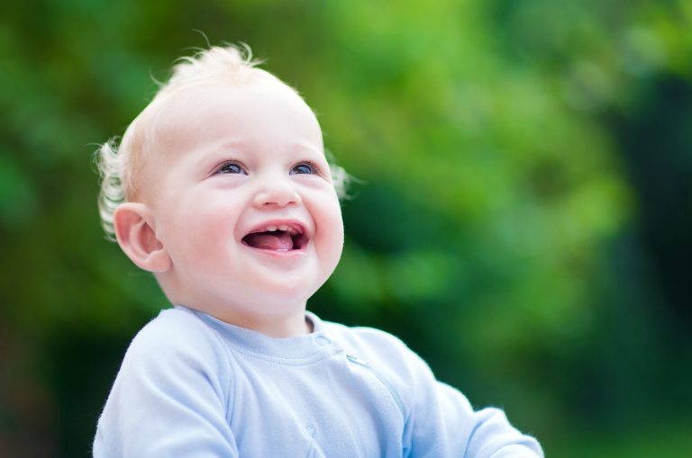 Baby boy laughing and showing a few teeth