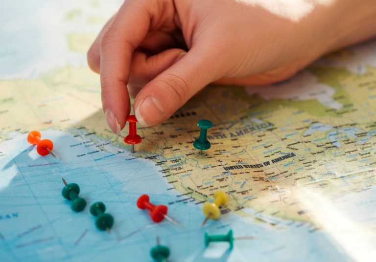 Woman's hand putting a pin into a map