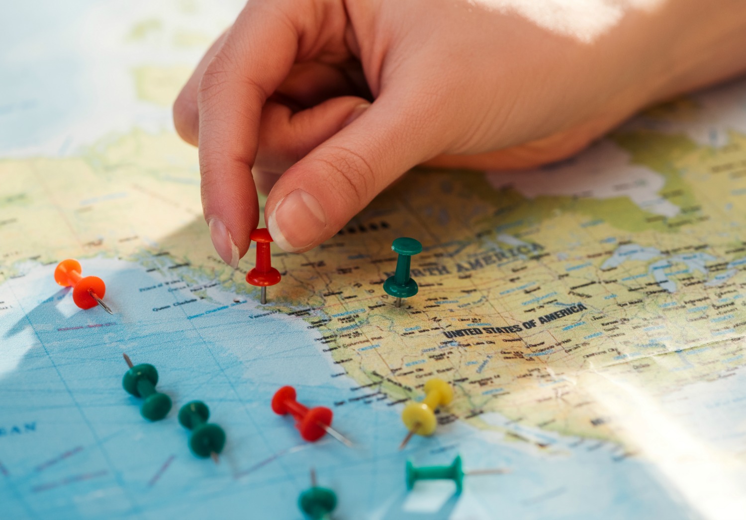 Woman's hand putting a pin into a map