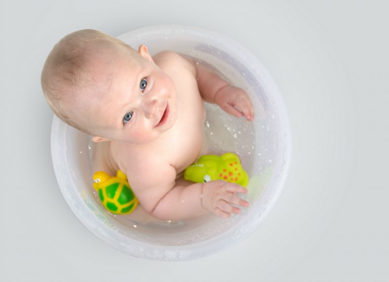 Baby having a bath in a bucket surrounded by toys - my review of Superdrug My Little Star baby bath range