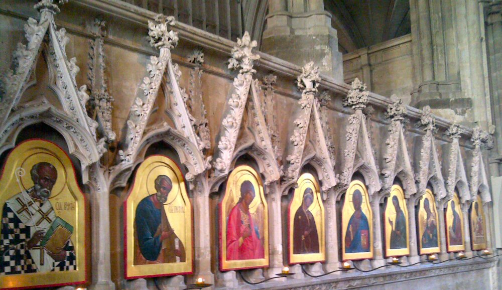 Gilded icons under carved stone arches in Winchester cathedral