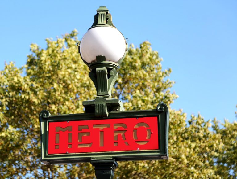 Red Metro sign in Paris against a blue sky - discovering things to do in Paris with toddlers