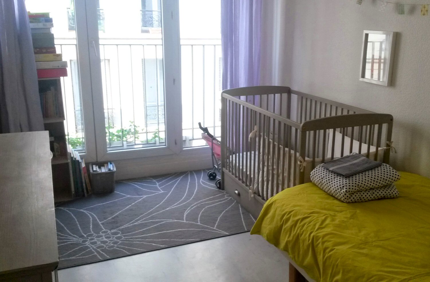 Cot at the end of a single bed in the bedroom of our Paris AirBNB