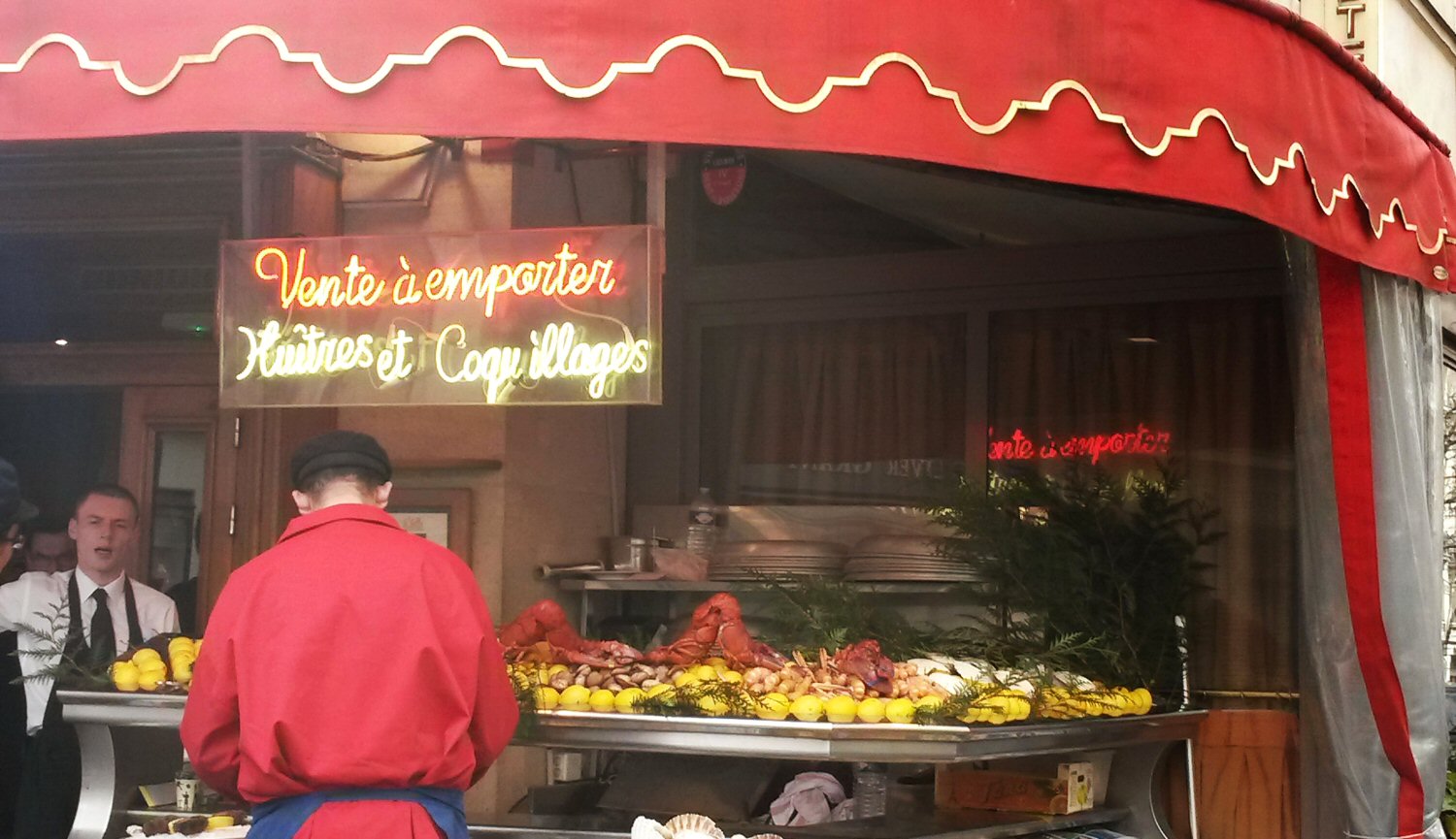 Sign for a restaurant selling oysters to take away - one good reason why walking around the city is one of my top tips for Paris with a toddler