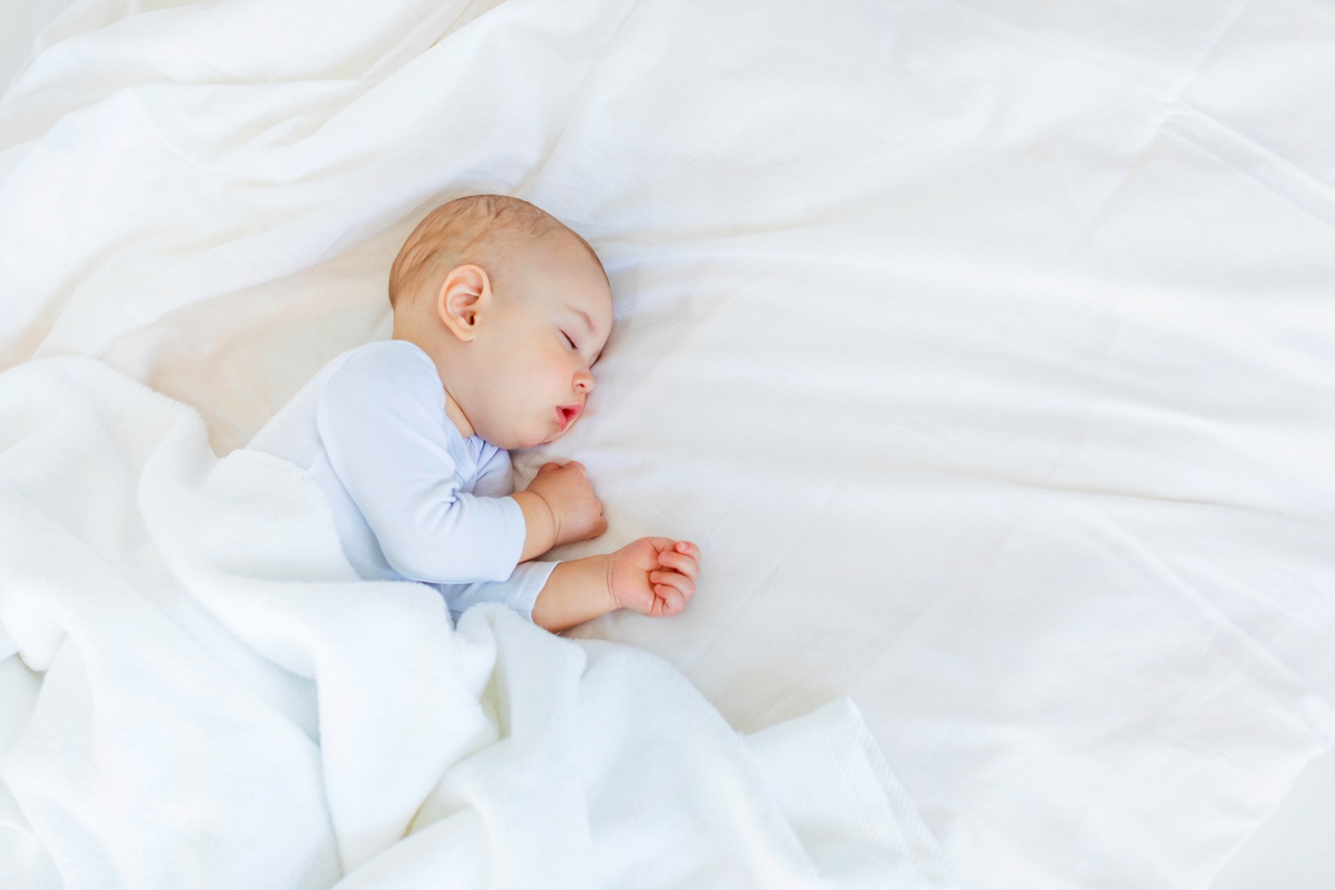 Baby asleep in a big bed - there's more choice of London hotel rooms sleeping five if you're travelling with an infant