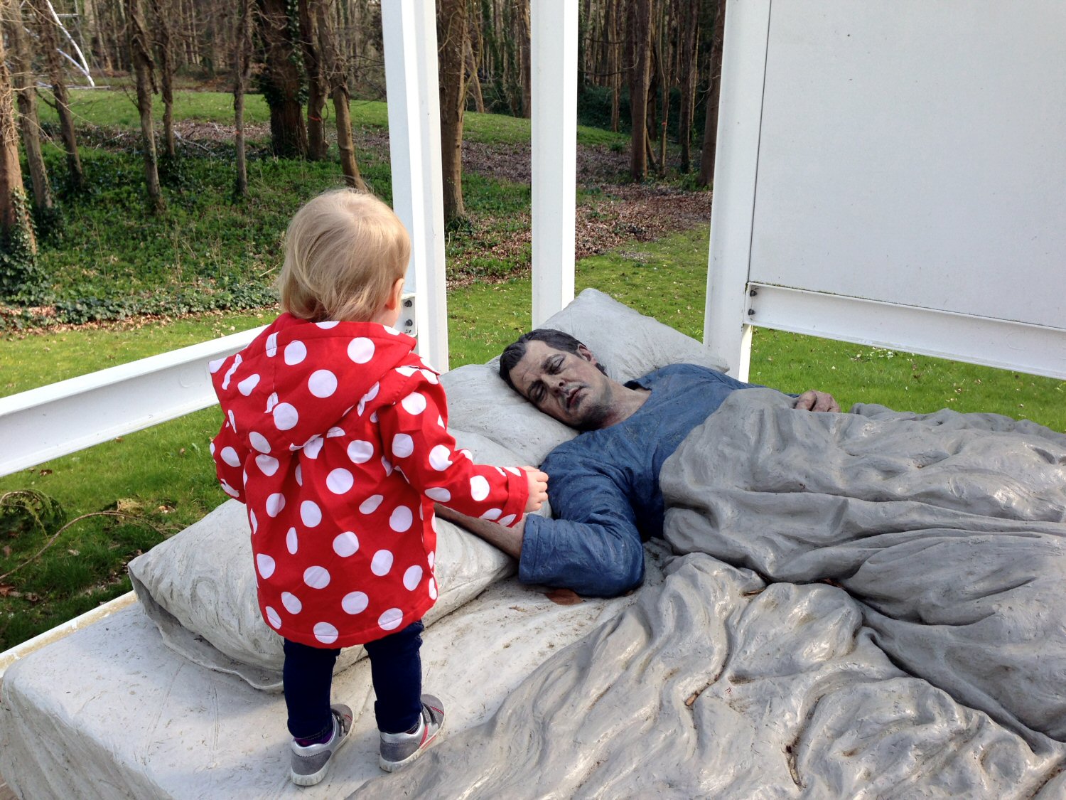 My toddler daughter with a sleeping man sculpture - discovering the Cass Sculpture Foundation with kids
