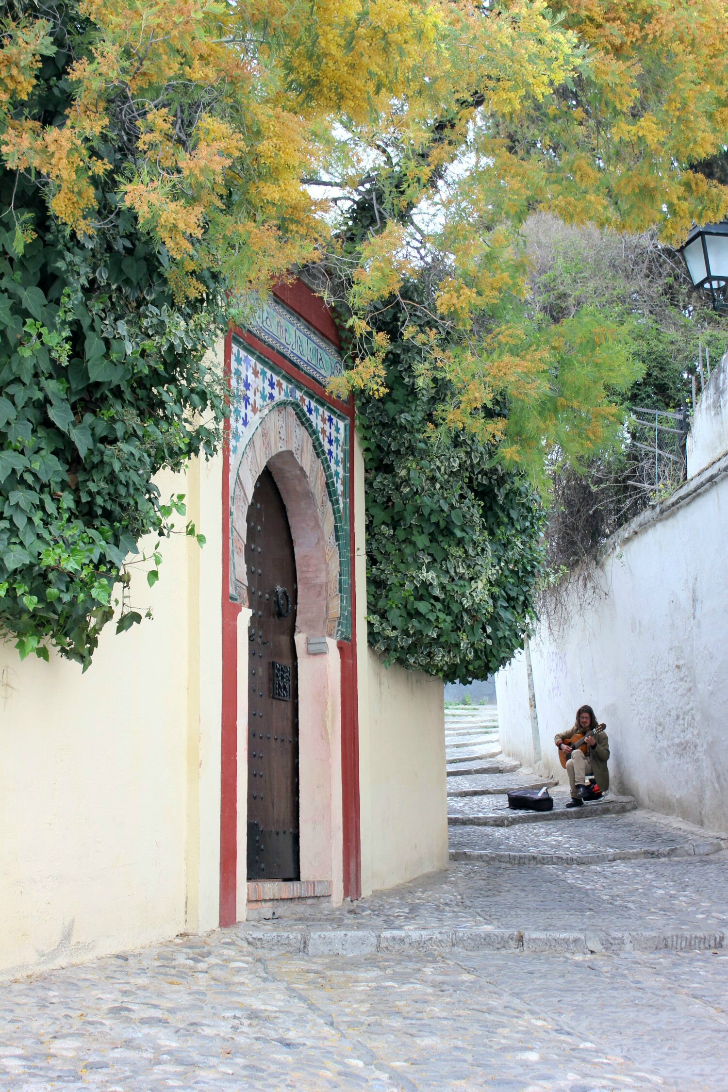 Hombre toca la guitarra en una de las callejuelas encaladas del Albaicín de Granada Granada en imágenes: mis fotos de Granada, España