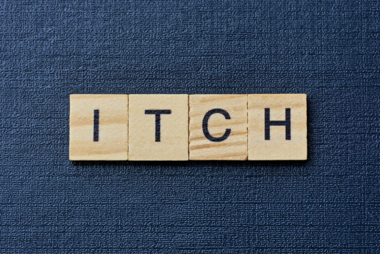Scrabble tiles reading Itch against a dark blue background - my mosquito bite zapper review of Zap It mosquito bite relief