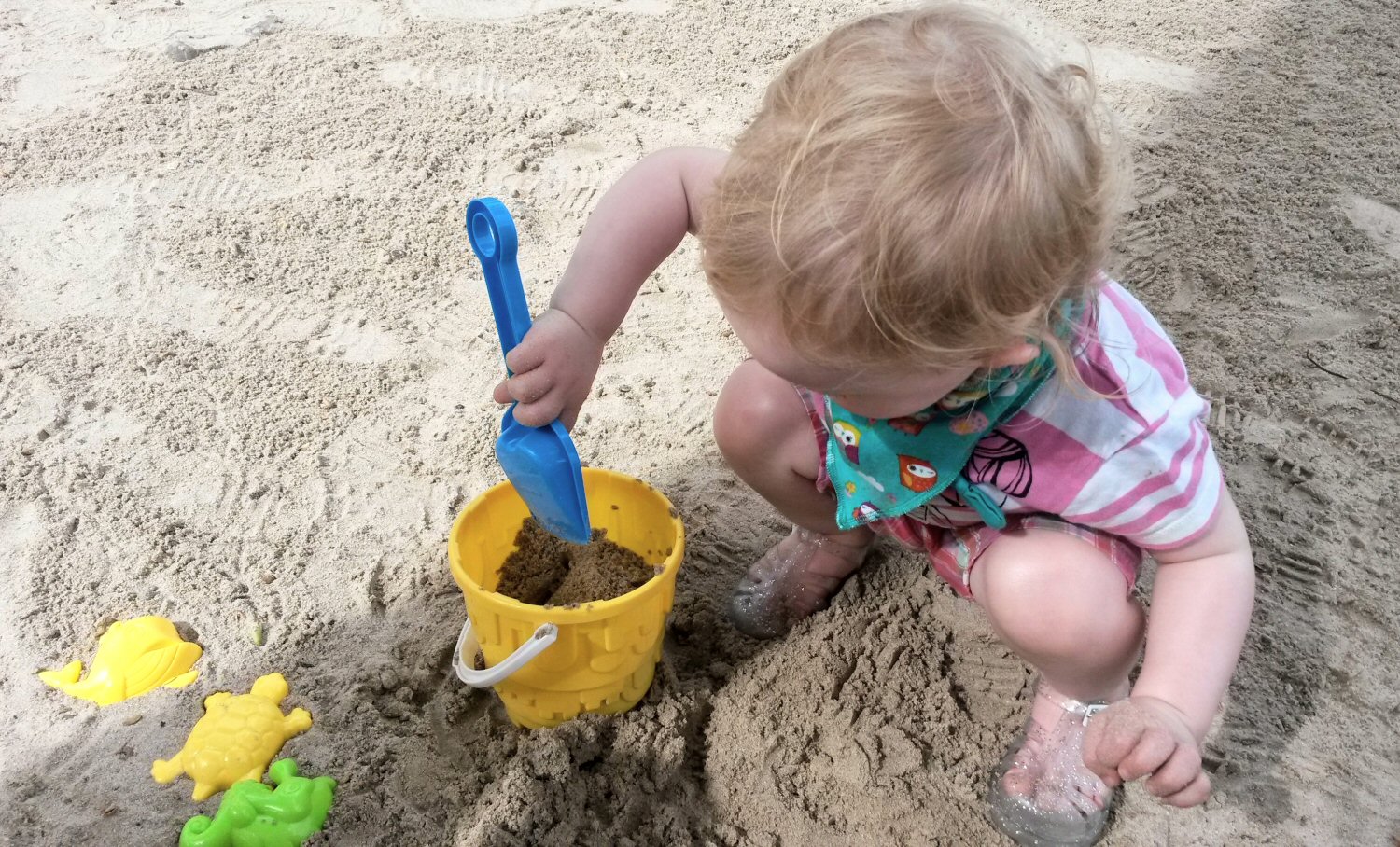 My toddler daughter with bucket and spade on the beach at St James Club Morgan Bay in St Lucia