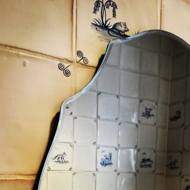 Tiles and mirror in the toilets at Packwood House National Trust property in Warwickshire