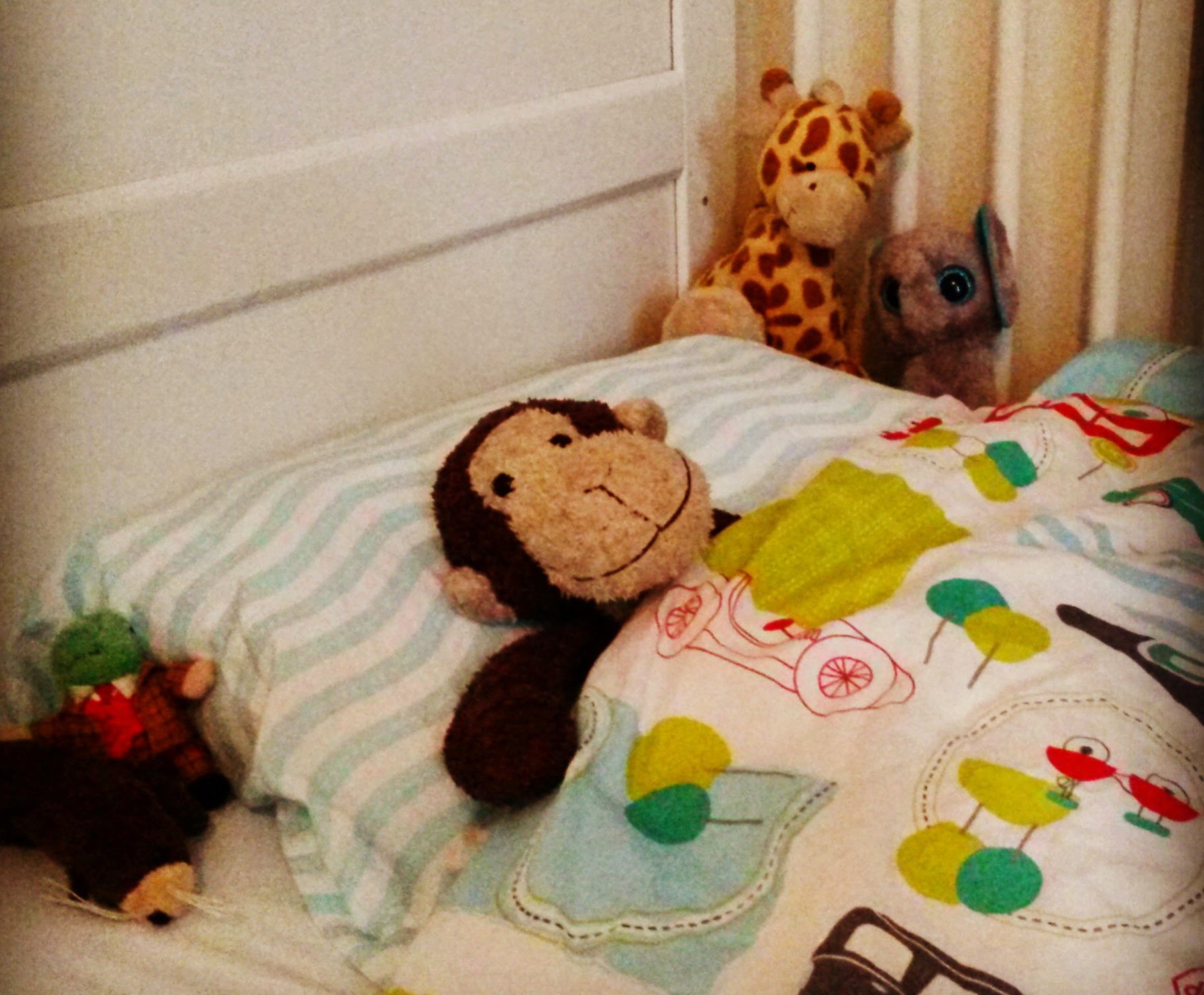Toy monkey tucked up in my toddler's bed - reviewing the Gro to Bed toddler cot bedding