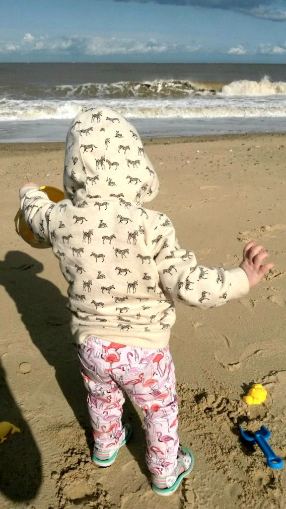 My young daughter on the beach in Suffolk with sand toys - our last trip of the Take 12 Trips challenge