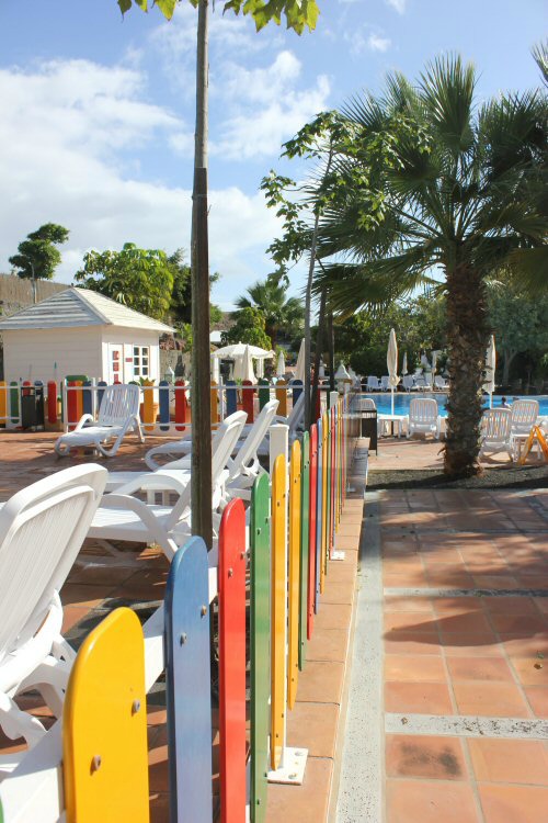 Brightly coloured fence with the kids pool in the background at the Gran Castillo hotel in Lanzarote