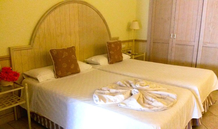 Twin beds with white linen cushion and towel at the Gran Castillo hotel in Lanzarote