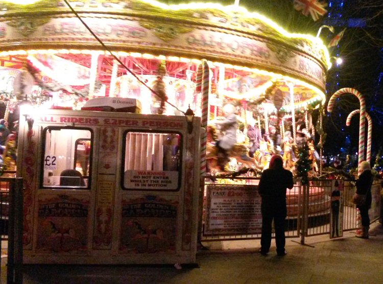 Brightly lit carousel at the Christmas market on the South Bank twirling around