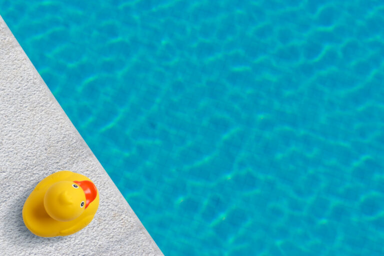 Yellow rubber duck by the edge of a swimming pool - my Swim Fin review, testing the shark fin swimming aid