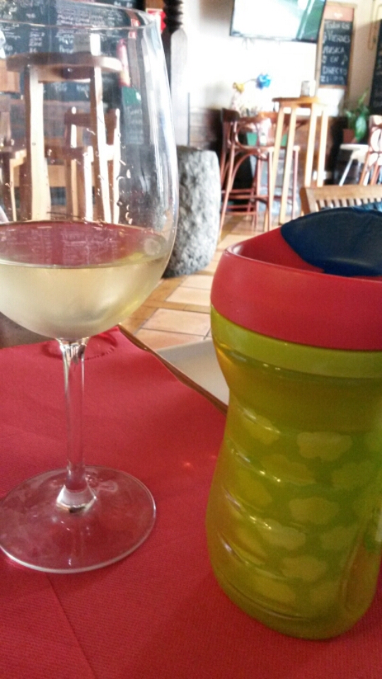 My toddler's drinking bottle next to a glass of wine in a tapas bar in Lanzarote