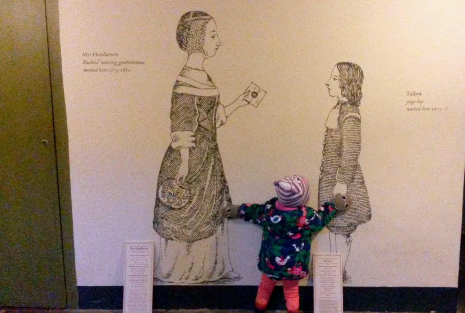 Toddler next to two pictures showing life below stairs in Ham House, Surrey