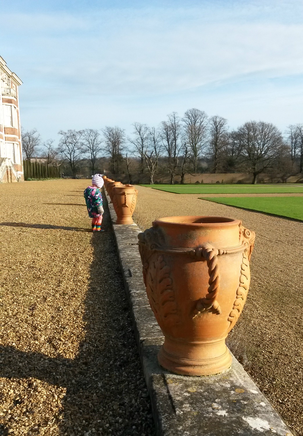 My toddler investigating one of the decorative pots on the terrace at Ham House in Surrey