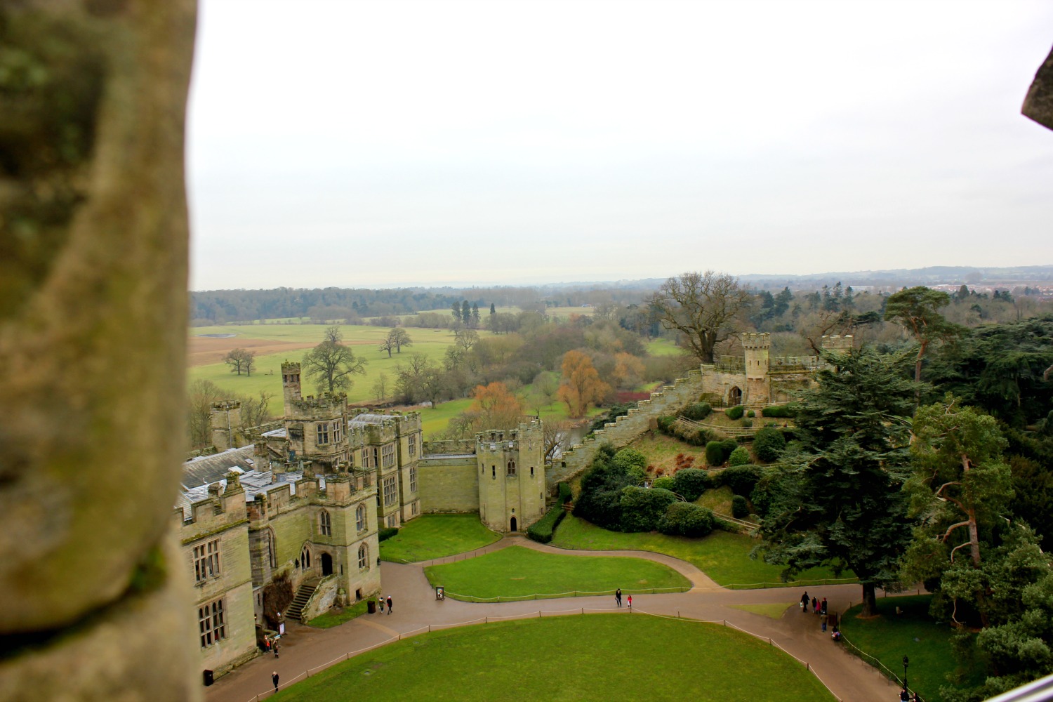 Looking down from the walls onto the grassy courtyard and towers - visiting Warwick castle with a toddler
