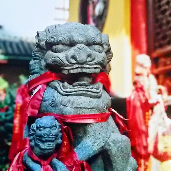 Stone lion with red ribbons in its mouth in China for the Thursday Travel Treat