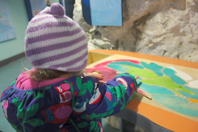 My daughter tests out the dinosaur jigsaw at Dinosaur Isle