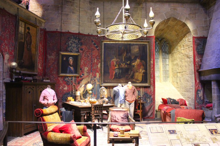 Costumed models of Ron, Hermione and Harry in the Gryffindor dormitory at Hogwarts