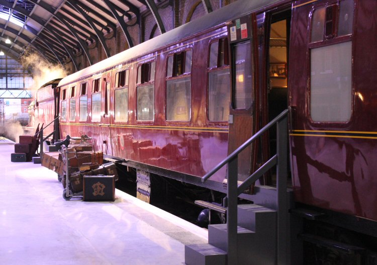 Luggage by the sides of the Hogwarts Express and stairs to access the train