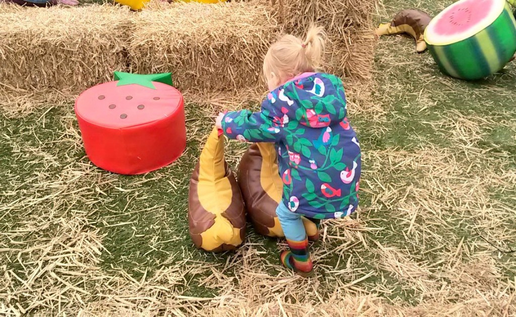My daughter plays with some of the props among the fruit and vegetables of the Shaun the Sheep maze at Kew Gardens