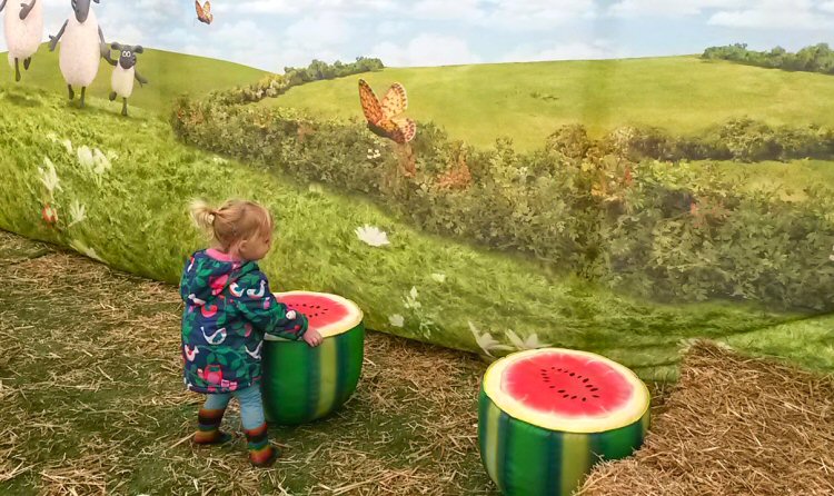 My daughter playing with oversized watermelon halves in the barn for Shaun the Sheep at Kew Gardens