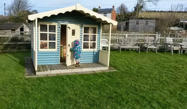 My daughter at the wooden play house at Nettlecombe Farm on the Isle of Wight
