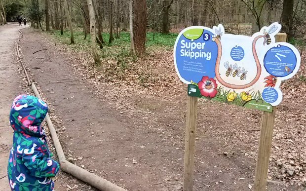 My toddler looks at the Super skipping sign for one of the activities on the Superworm trail