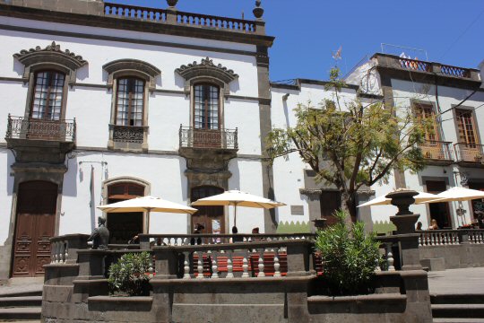 Umbrellas above tables in front of a traditional white washed building in Arucas, Gran Canaria