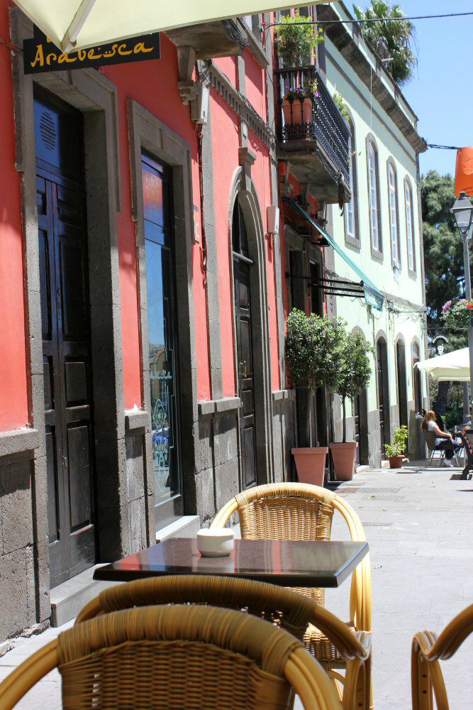 Table and chairs outside the brightly coloured buildings of Arucas in Gran Canaria