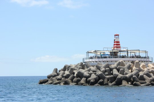 Striped lighthouse at the entrance to the marina at Puerto de Mogan, Gran Canaria