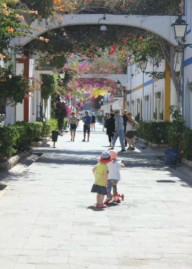 My daughter and her friend with scooter in the streets of Puerto de Mogan, Gran Canaria