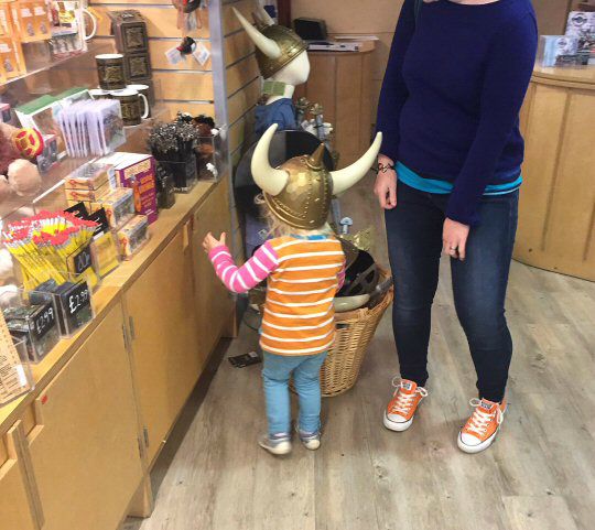 My toddler daughter in huge horned Viking helmet at the Cornwall National Maritime Musem shop