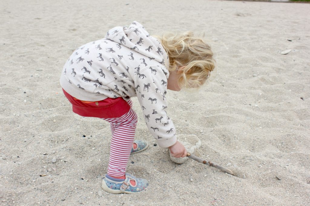My toddler daughter plays in the sand on Gyllyngvase beach in Falmouth