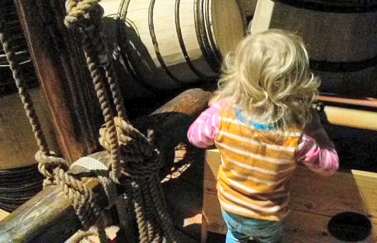Toddler exploring the Walrus replica Viking boat at the National Maritime Museum Cornwall