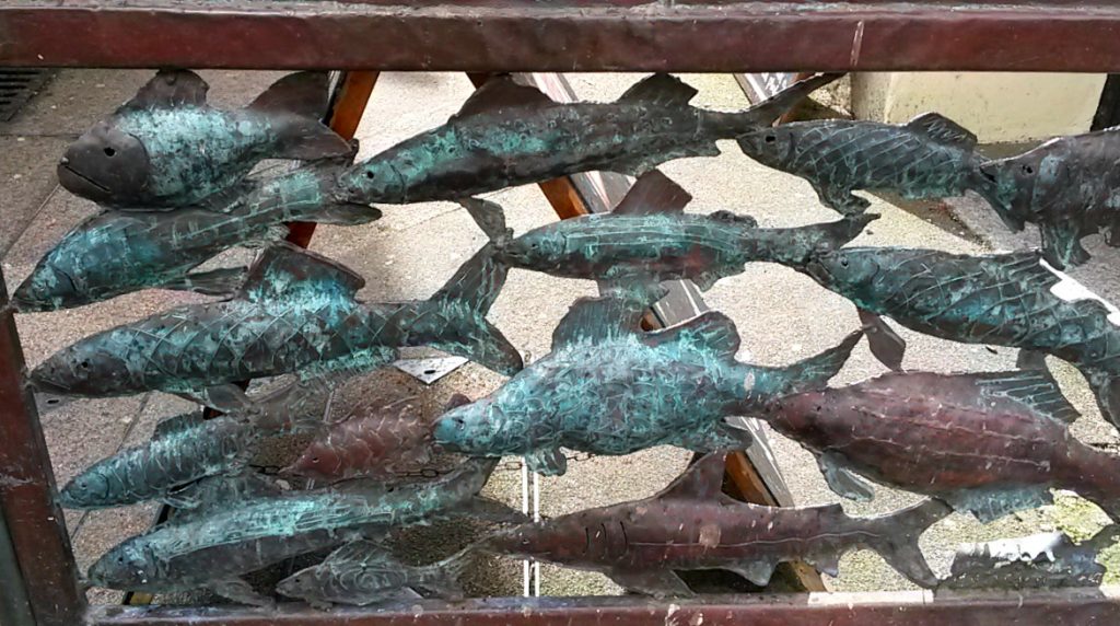 Decorative metal fish in a gate by the street in Falmouth, Cornwall