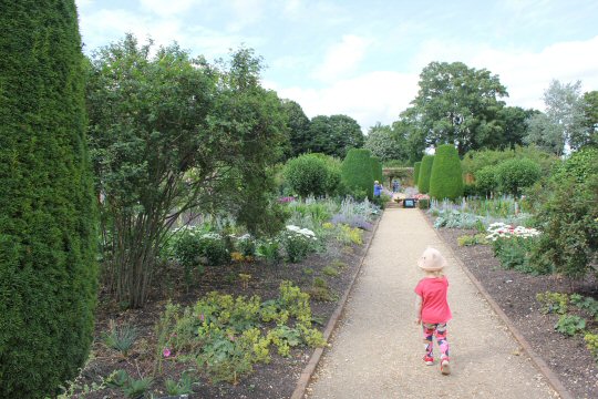 My daughter walks along a path through the gardens at Mottisfont in Hampshire