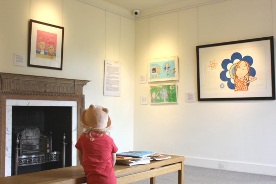 My daughter looking at illustrations in the Lauren Child exhibition at Mottisfont