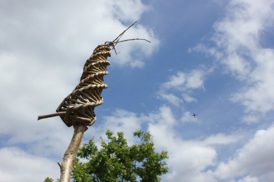 Bug hotel on a stick high against a blue sky