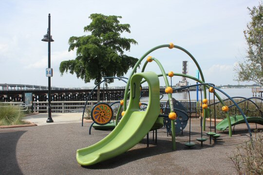 Green slide among play equipment near the Bradenton Riverwalk